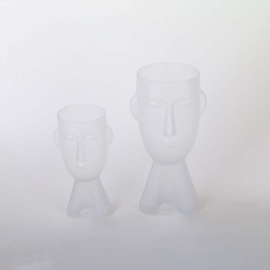 Set of frosted glass vases in abstract face design matte white finish decorative modern accents light on white background for home.