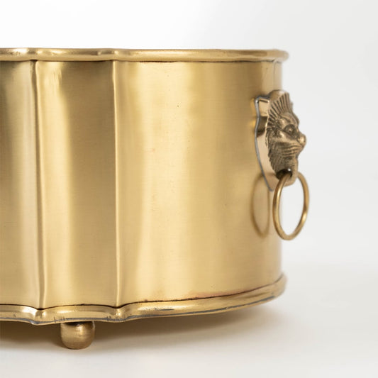 A detailed closeup of the brass fruit bowl showing the ornate engraved pattern and smooth polished finish with raised rounded feet adding a luxurious handcrafted look.