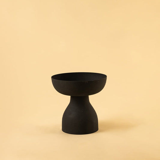 Black pedestal bowl with matte textured finish displayed on a clean white background for bold minimal home decor styling.