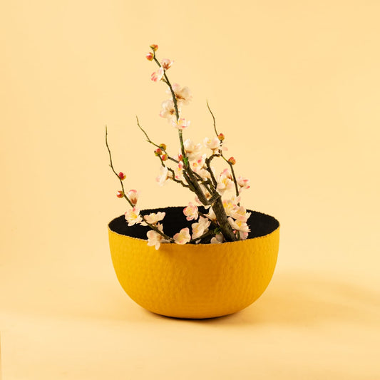 Bold yellow textured metal bowl displayed in a soft neutral scene bringing vibrant modern style to home decor.