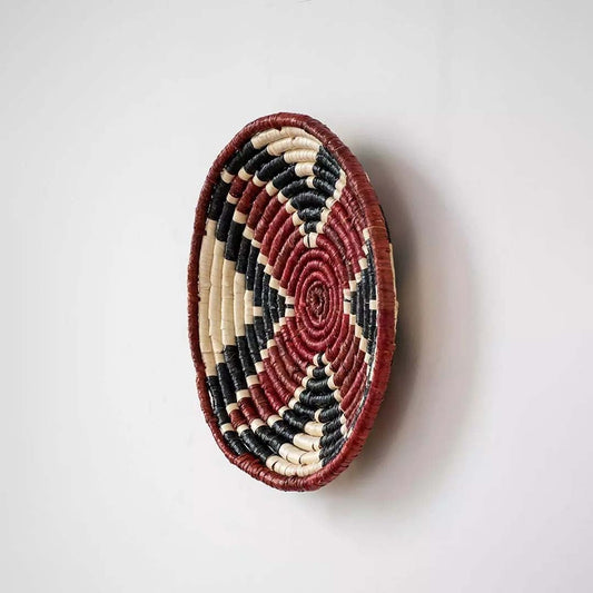 Side profile of handcrafted woven wall plate showing its curved rim and tightly woven natural fiber build.