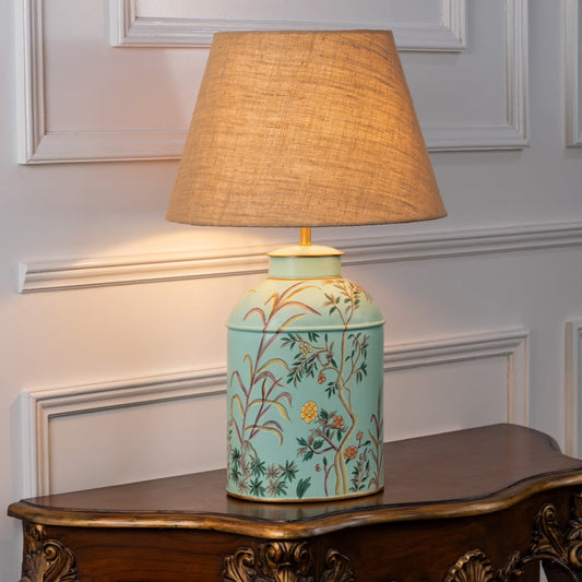 Tropical Garden sky blue table lamp on white background with light on offering calming glow and breezy interior decor aesthetic.