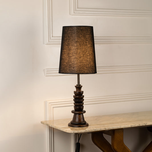 Table lamp with textured dark shade and carved base ideal for classic bedroom or living room table decor placement on clean background.
