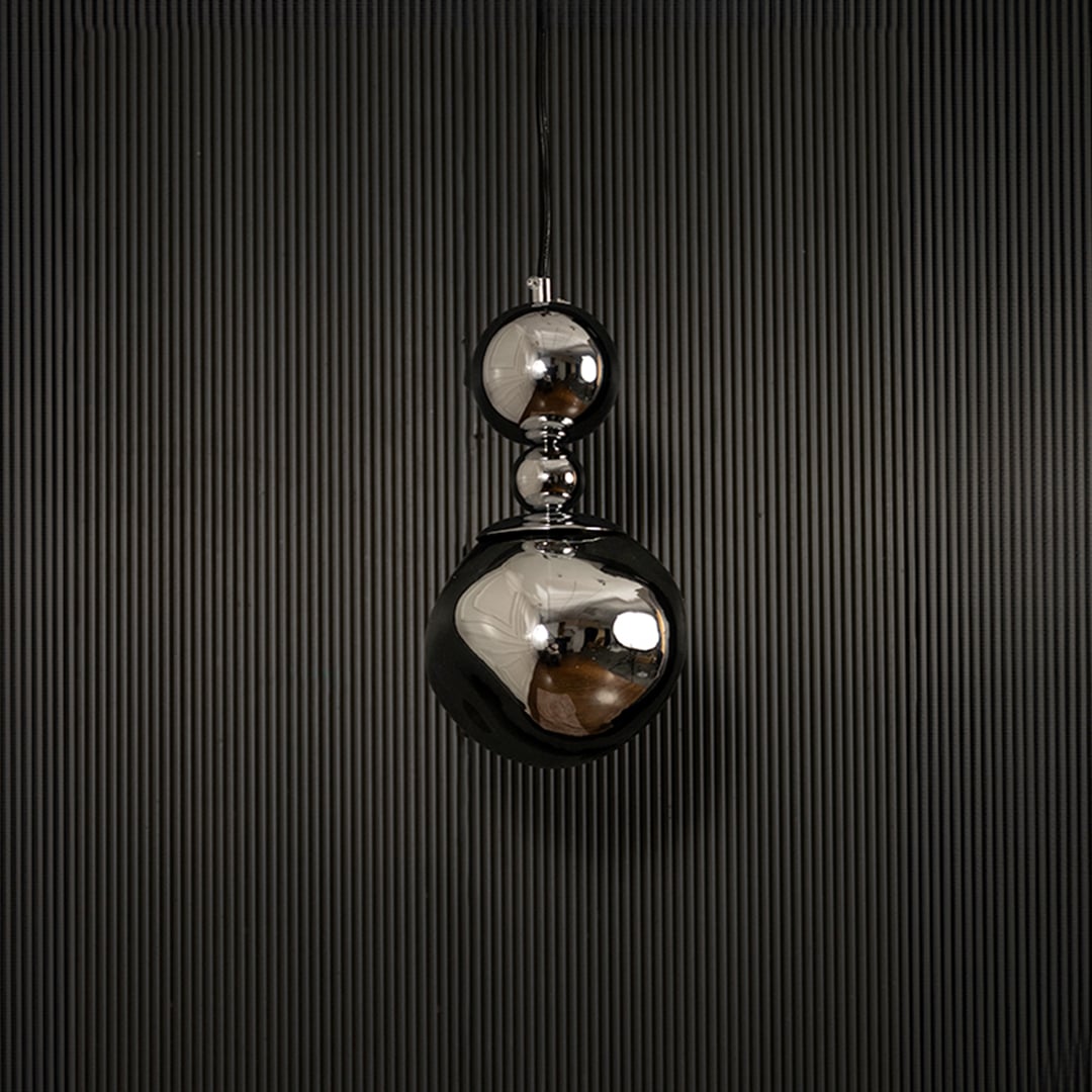 Reflective chrome pendant light with silver finish displayed on dark background with lights off highlighting texture.