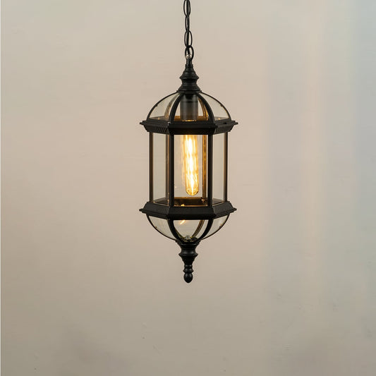Illuminated antique gold outdoor pendant lantern with frosted glass panels glowing warm against a clean plain white studio background.