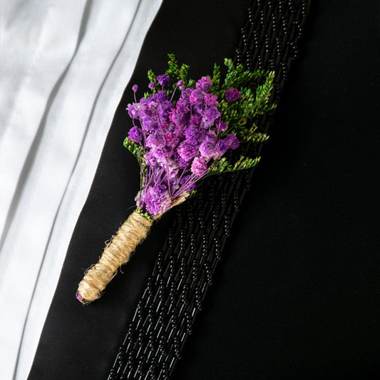 Closeup of preserved purple flower bouquet with green leaves wrapped in natural jute – artificial decorative flower.