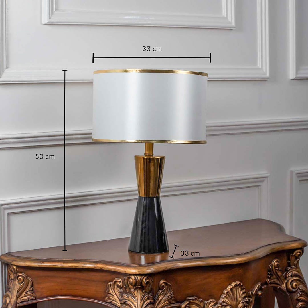 Black and gold ceramic table lamp with fabric shade shown with 50cm height and 33cm width dimensions.