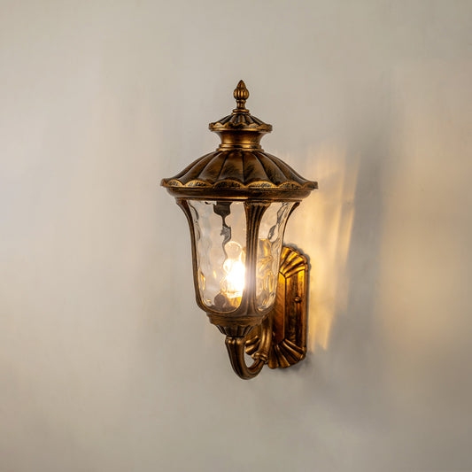 Vintage bronze outdoor wall light glowing on white wall for classic exterior entryway lighting decor.