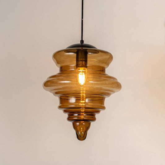 Amber ribbed glass pendant light with layered glass design and exposed bulb for warm modern ceiling lighting.