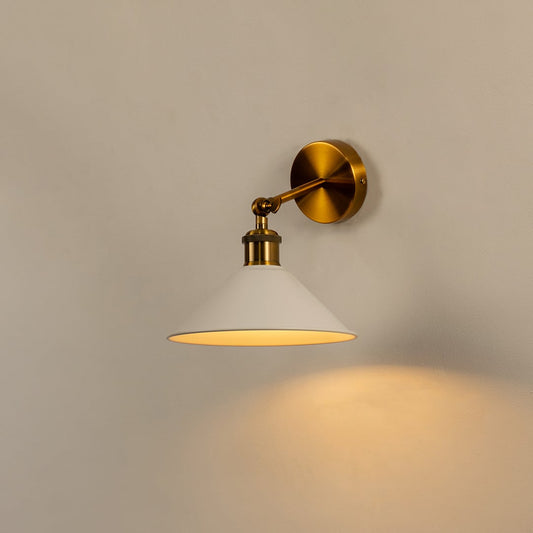 White cone wall light with brass fixture glowing warmly on white wall bringing modern elegance to minimalist interiors.