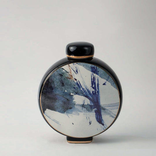 Elegant round ceramic vase in black with artistic blue and white pattern displayed on white background for interior decor.