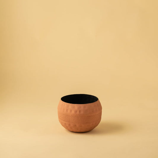 Terracotta round textured planter bowl with black interior photographed on a plain light background for a clean product display.