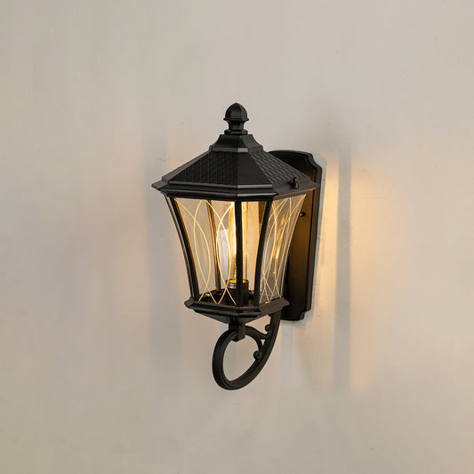 Black metal outdoor wall light glowing warmly on white wall for stylish exterior entryway lighting decor.