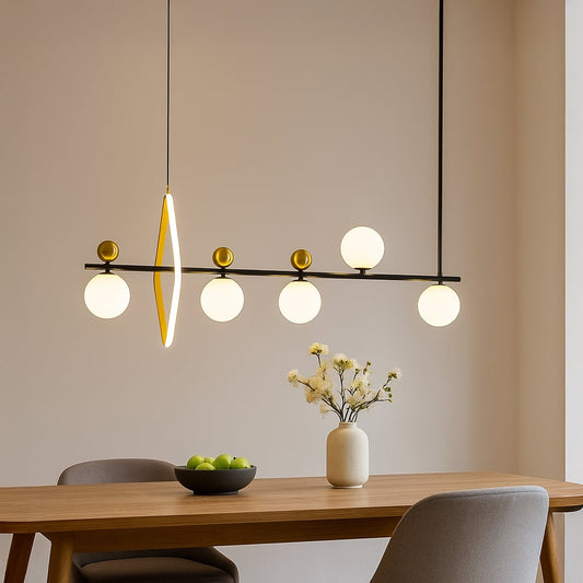 Modern linear pendant light with black metal frame gold accents and white glass globes suspended above dining table.