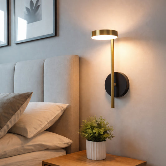 Modern wall light with gold metal rod design casting soft ambient glow styled beside bed creating cozy interior decor ambiance.