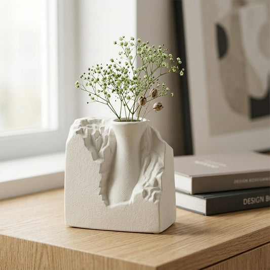 White ceramic flower vase with sculpted artistic design for elegant tabletop and shelf decor styling ideas.