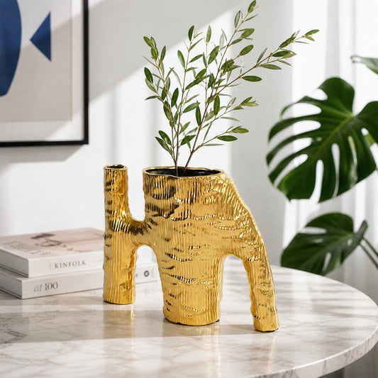 Gold textured metal elephant planter with green plant placed on marble table for modern home decor styling.