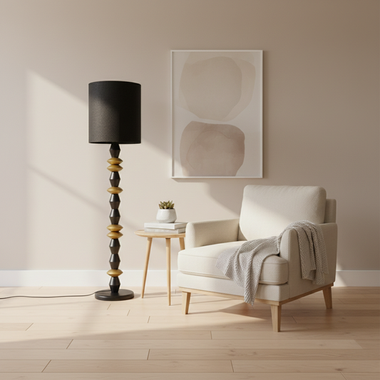 Floor lamp styled floor light beside soft armchair with black shade and stacked black gold metal base creating warm modern luxury Decor ambience.