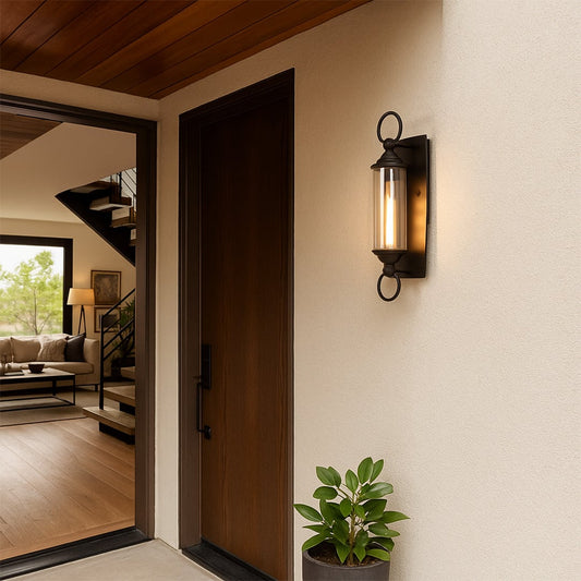 Black metal wall sconce with clear glass cylinder adds warm outdoor lighting and classic charm to entry or patio areas.