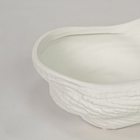 Closeup of white ceramic decorative bowl with textured handmade finish modern home decor accessory for table styling and living room display.