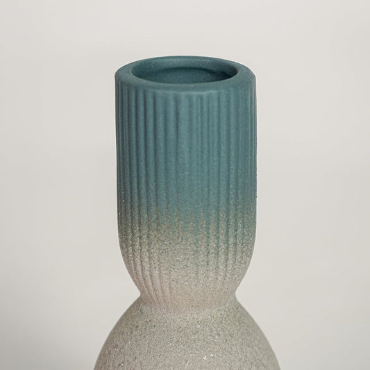 Detailed view of beige textured ceramic vase with smooth blue glazed neck showcasing modern handcrafted home decor styling.