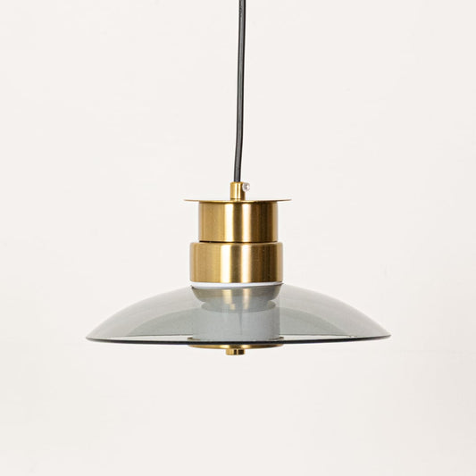 A smoked glass pendant light with gold detailing displayed with the bulb off against a smooth white background highlighting its form.