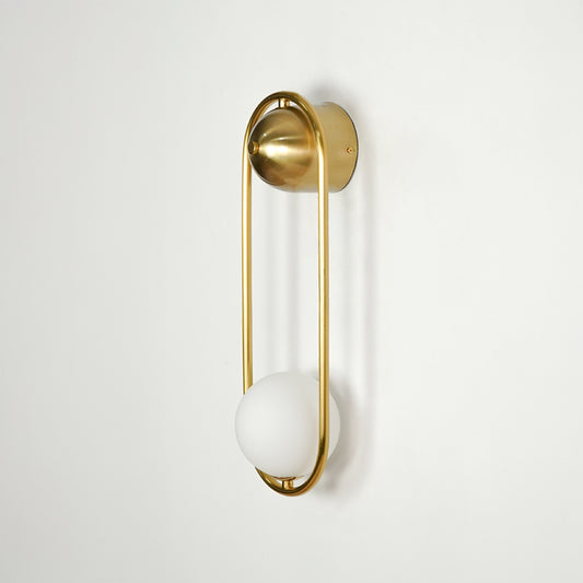 Gold metal wall light on white background with frosted globe shade for elegant modern interior decor.