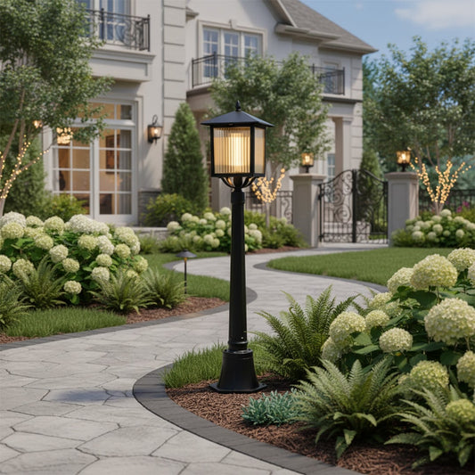 Traditional outdoor post light in black metal installed near garden plants enhancing landscape design with soft welcoming illumination.