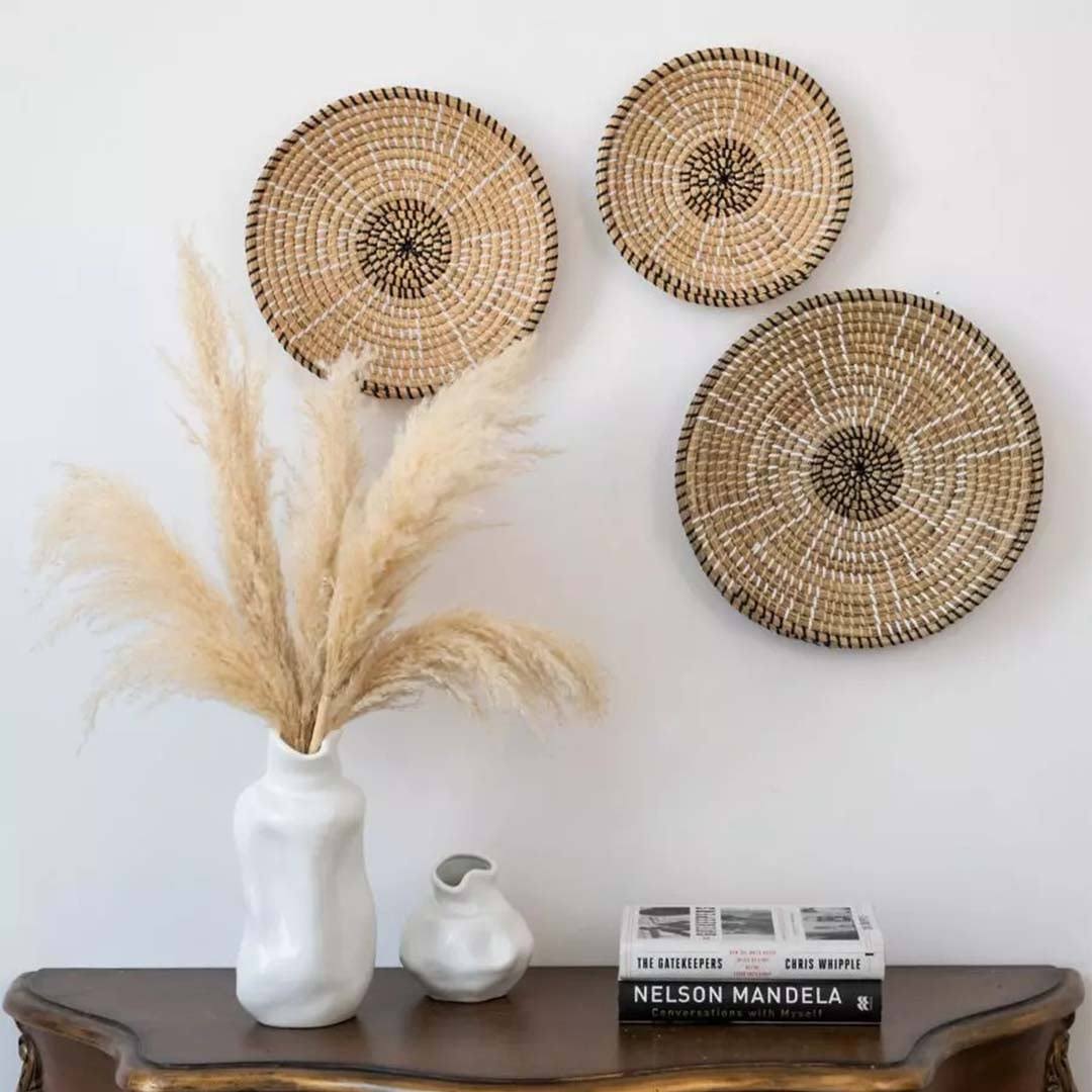 Handwoven seagrass wall basket decor set in natural beige displayed above a console table creating warm boho home style.