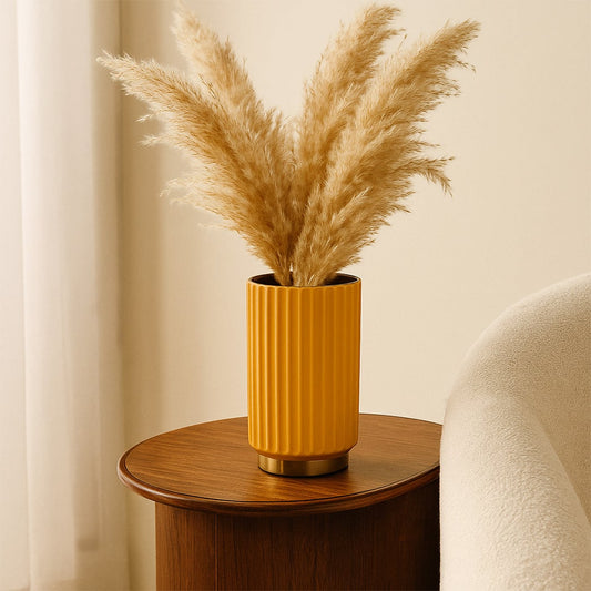 Yellow ceramic vase styled with dried pampas grass on side table creating warm natural accent for modern living room Decor.