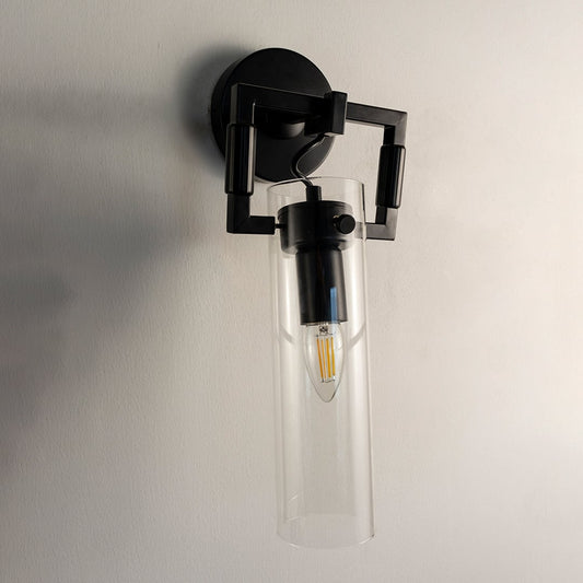 Modern black wall light with clear glass shade turned off on white wall showcasing elegant industrial design.