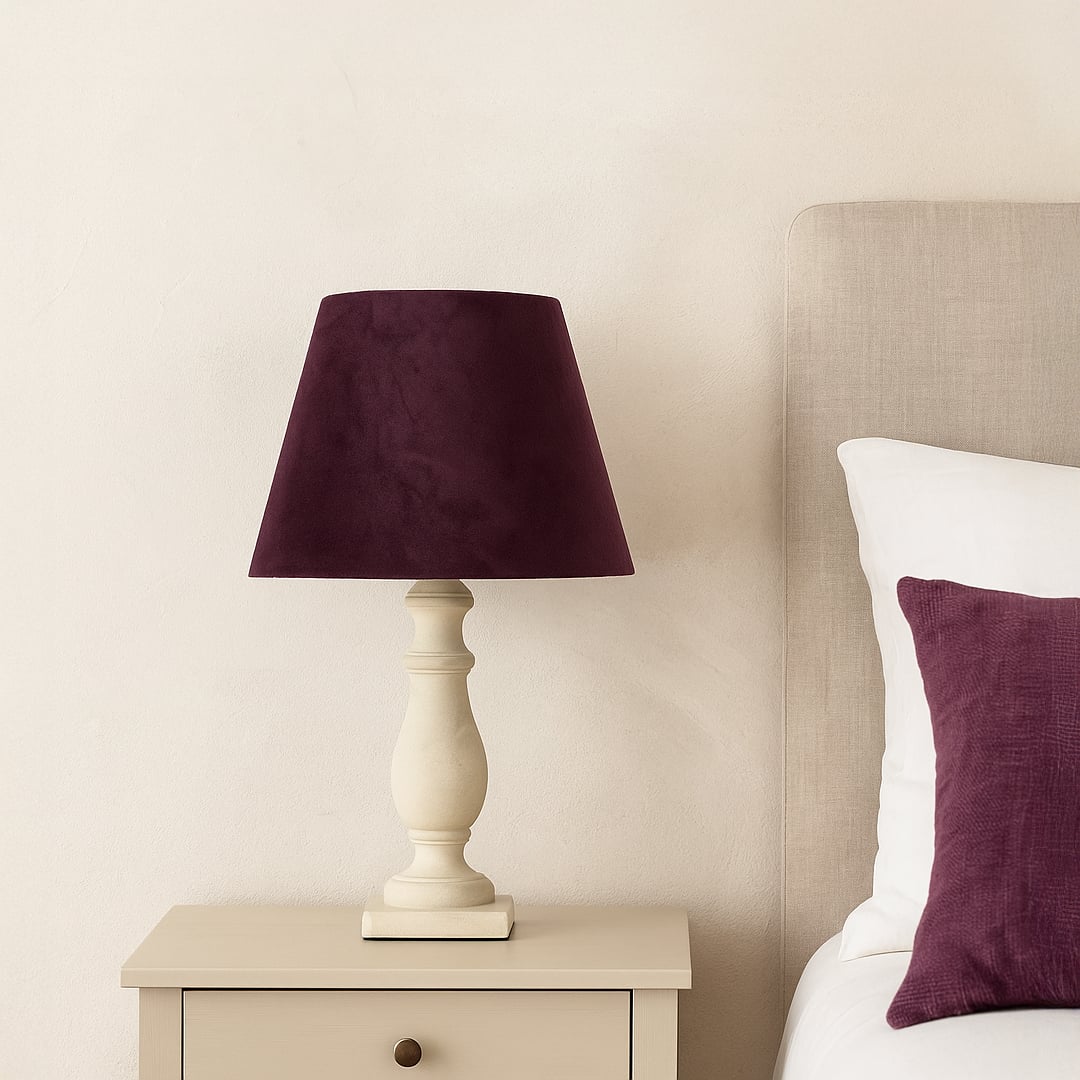 Deep plum tapered lampshade displayed in a soft styled setting showing its elegant velvet texture in a warm refined lifestyle look.
