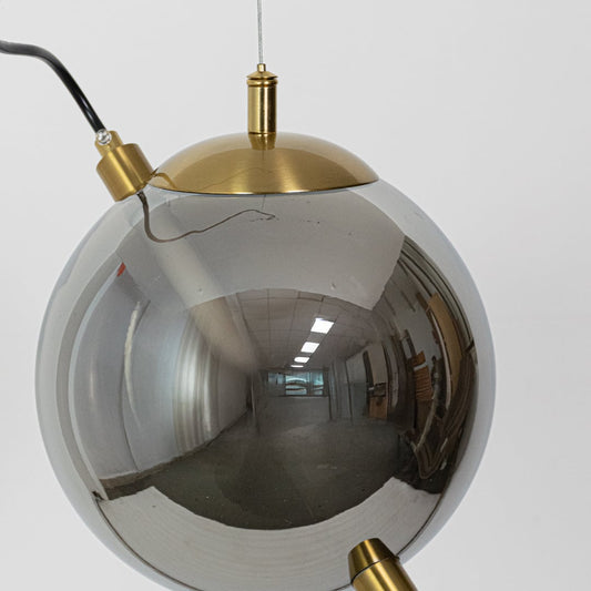 A detailed view of a reflective globe pendant light highlighting the metallic finish and sleek rod centerpiece for a modern decorative appeal.