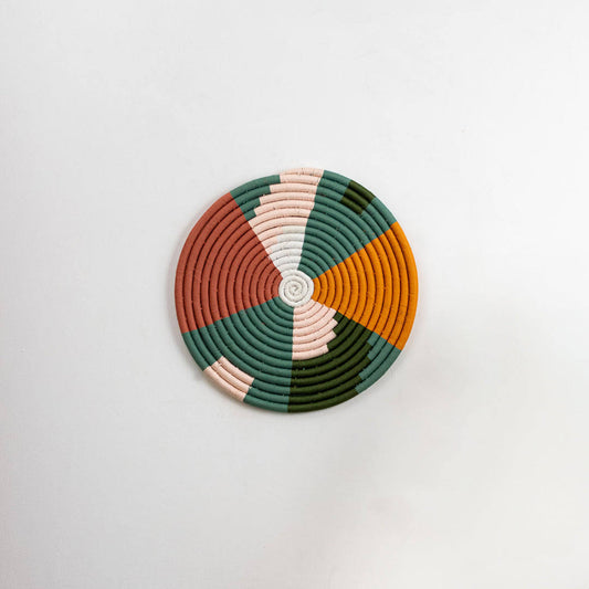 Round multicolor seagrass wall basket with green terracotta white and mustard pattern on white background image.