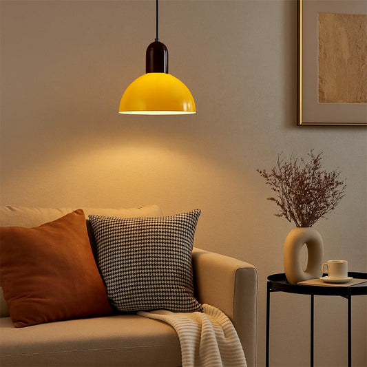Yellow metal pendant light hanging above sofa creating cozy ambient lighting in a contemporary living room.