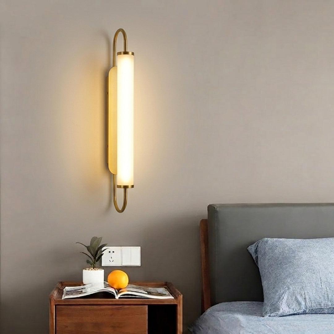 Gold metal wall light lifestyle image with warm LED glow for elegant modern bedroom interior decor.