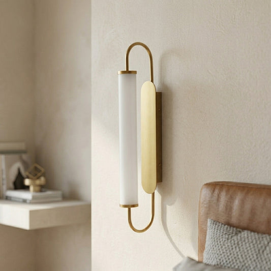 Gold metal wall light lifestyle image with frosted glass shade for cozy modern bedroom wall decor.