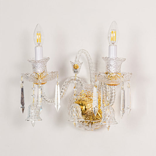 Gold and clear crystal wall light displayed on white background ideal for classic bright interior wall styling.