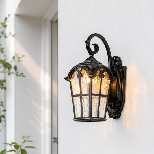 Black metal outdoor wall light with clear glass shade for porch entrance balcony and exterior walls with warm lighting.