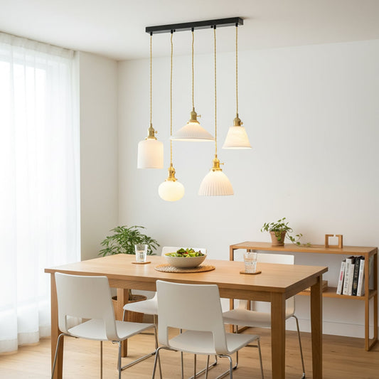 Elegant ceramic pendant cluster with white textured shades and gold fittings hanging from a black bar creating a warm modern focal point in the room.