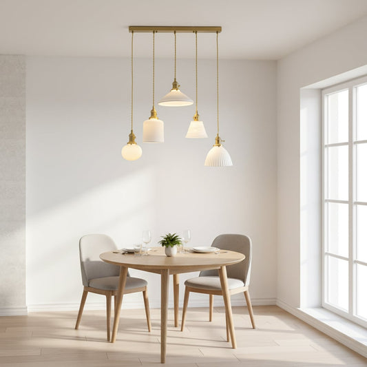 Elegant ceramic pendant cluster with white textured shades gold fittings and woven cords hanging from a gold bar creating a refined modern room look.