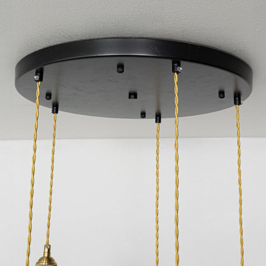 Close view of ceramic pendant lights showing ribbed and smooth white shades with gold fittings highlighting their handcrafted modern design.