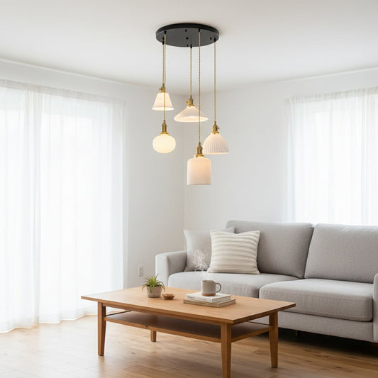 Elegant ceramic pendant cluster with mixed white textured shades and gold fittings hanging from a black ceiling plate creating a refined room look.
