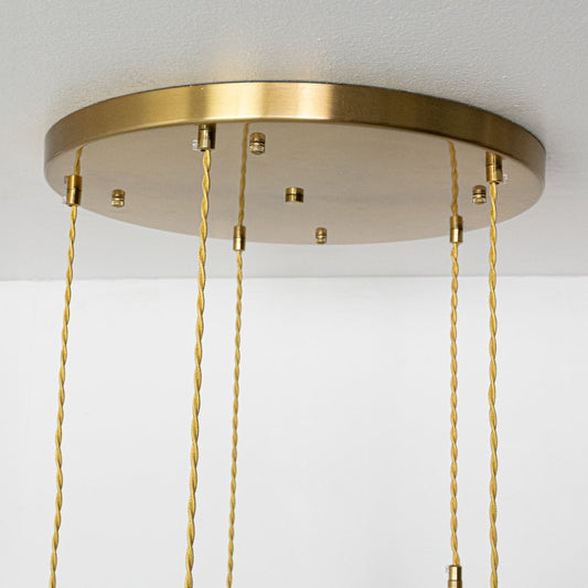 Close view of ceramic pendant lights with ribbed and smooth white shades and gold fittings highlighting their refined handcrafted design.