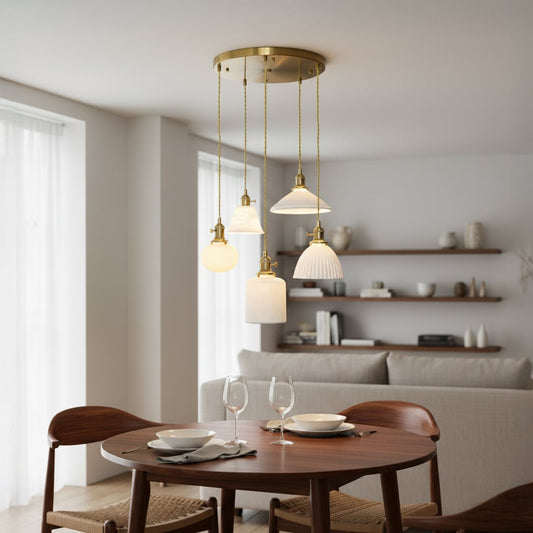 Elegant ceramic pendant cluster with white textured shades and gold fittings hanging from a round gold ceiling plate creating a warm modern room look.