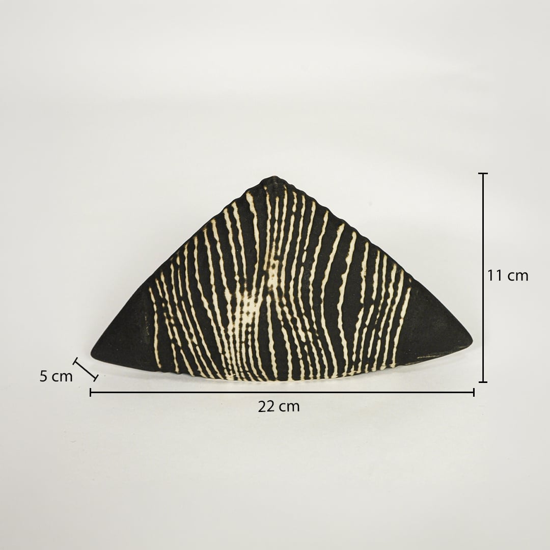 Black and beige ceramic triangle decor accent 22 cm width 11 cm height 5 cm depth shown on white background.