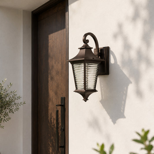 Outdoor lantern wall light mounted on a modern balcony wall illuminating a cozy rattan sofa set with green plants for a warm and stylish evening ambiance.