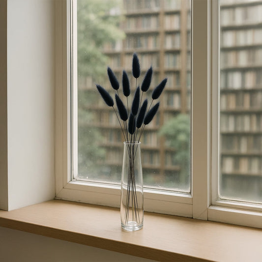 Clear glass vase with black dried stems styled on window sill creating minimalist natural accent for modern home Decor.