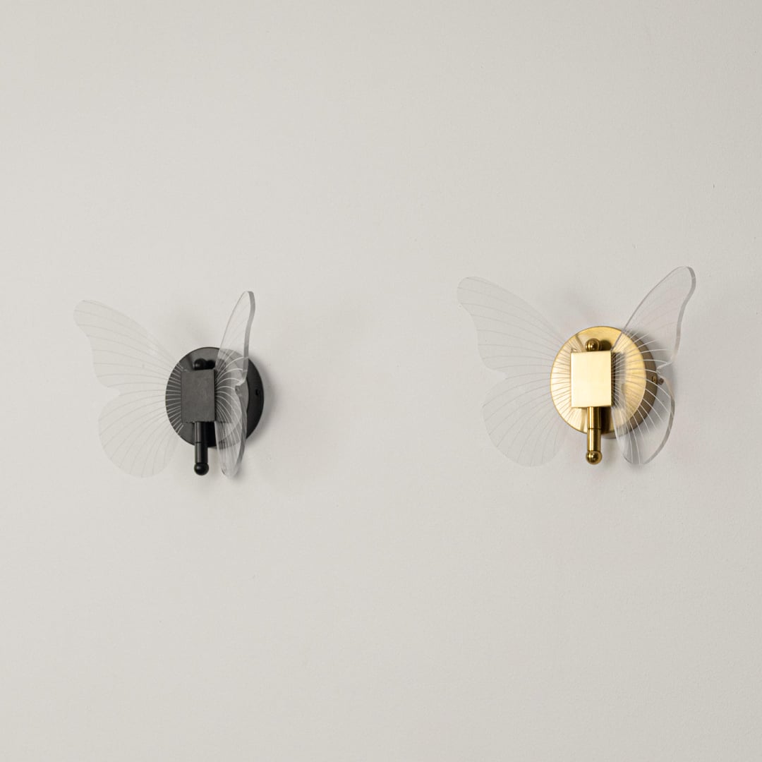 Gold butterfly wall light with clear acrylic wings shown on a white background with lights off for product clarity.