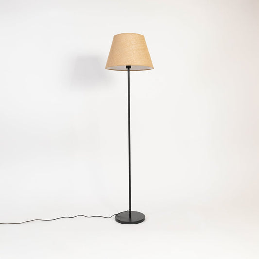 Beige floor lamp with fabric shade and black base displayed turned off against an off-white background.